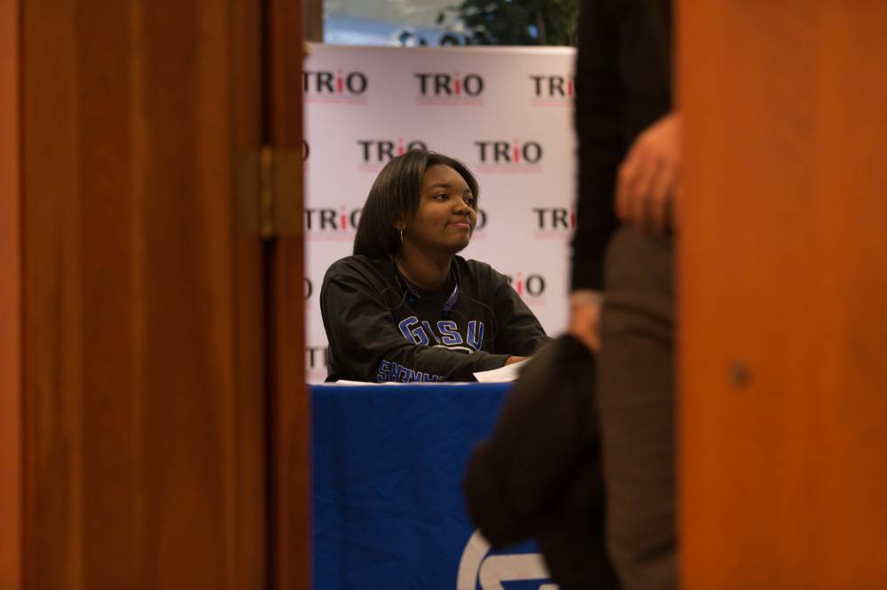 Image of student worker seated at sign in table